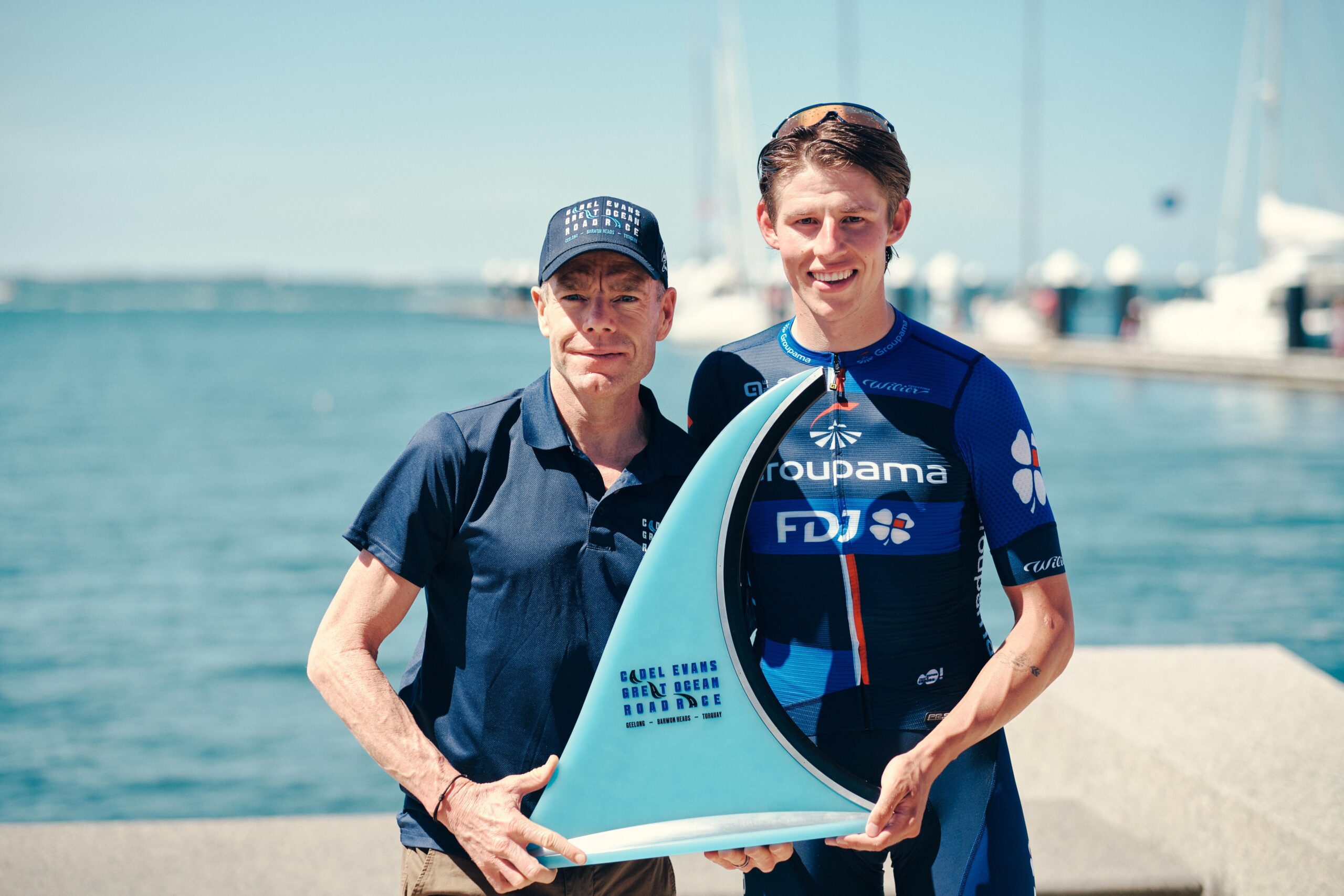 Cadel Evans and 2024 Road Race winner Laurence Pithie with the trophy